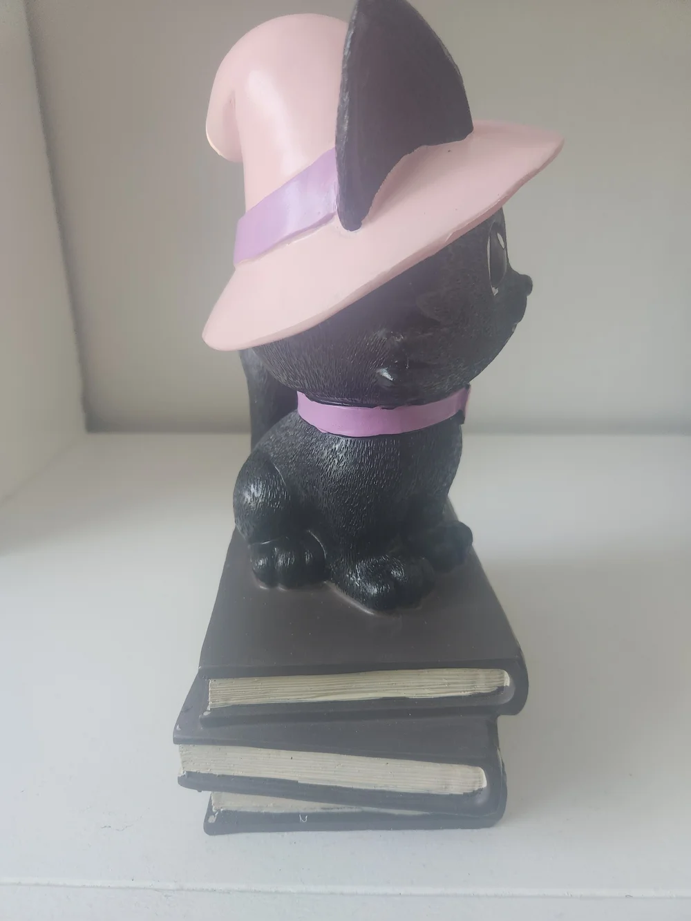 Black Cat Wearing Pink Witches Hat Sitting On Top Of Books Figuring